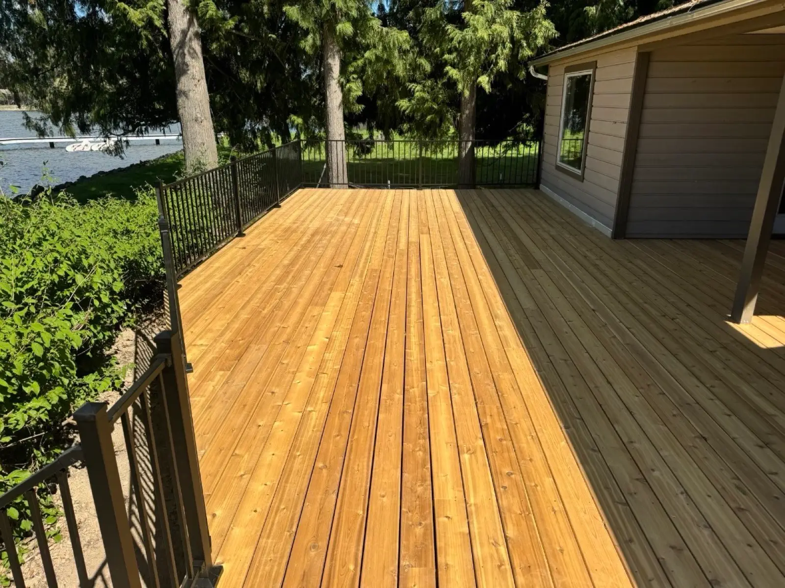 New cedar deck with black metal railing overlooking the water