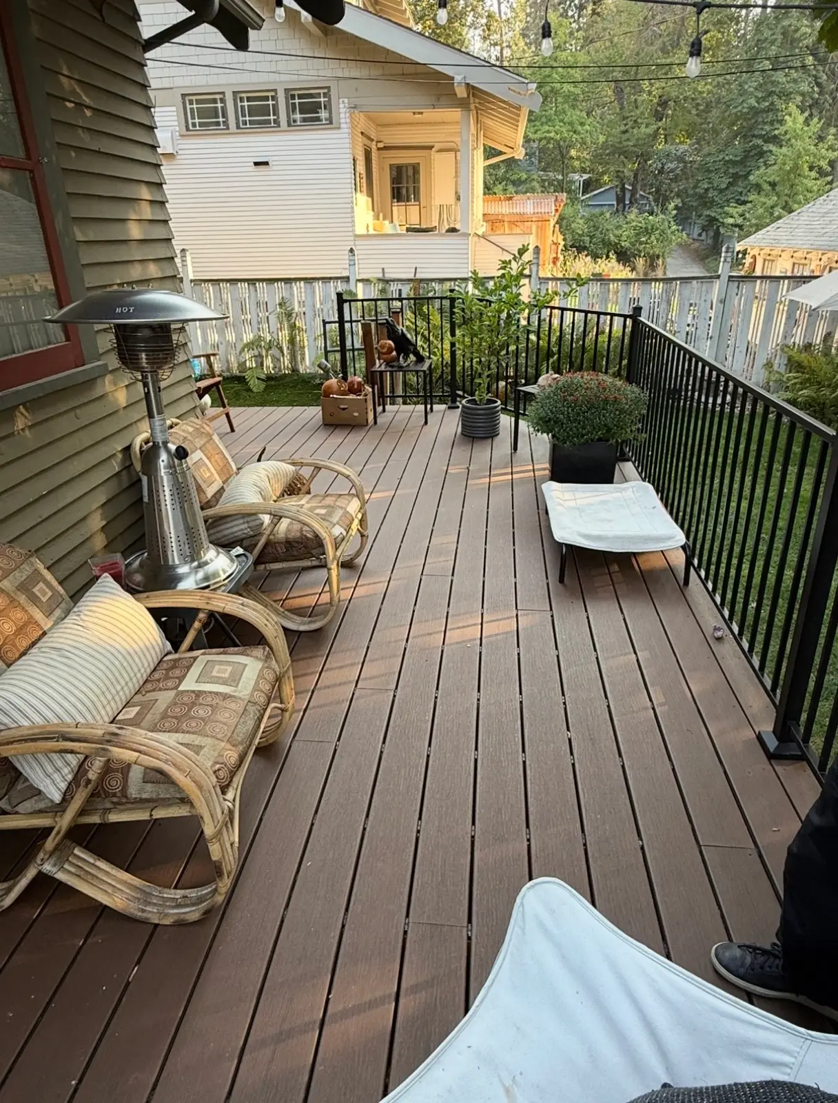 Finished composite deck with black railing and outdoor seating at dusk